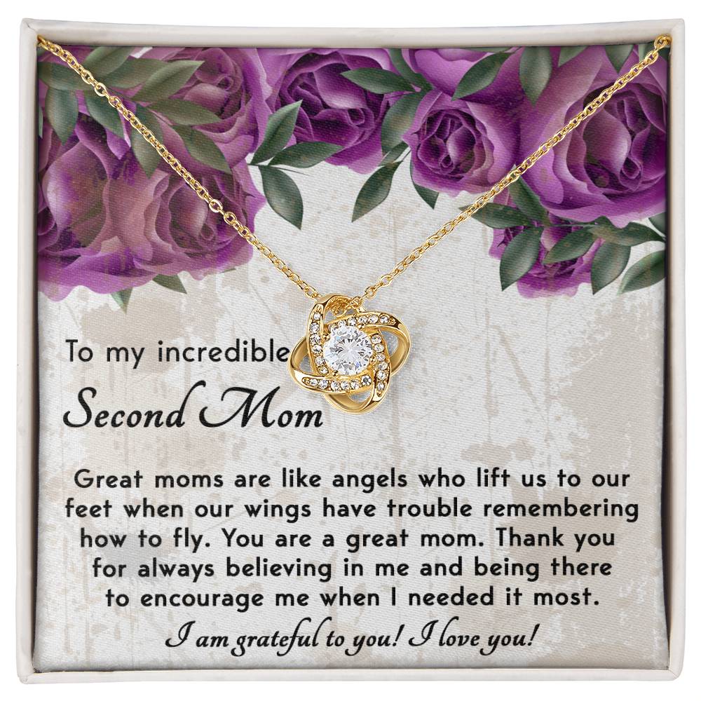 The "To Bonus Mom, Grateful For You - Love Knot Necklace" is showcased in a decorative box adorned with a floral border and cubic zirconia crystals. The heartfelt message expresses gratitude to a "second mom," making this personalized gift truly special.