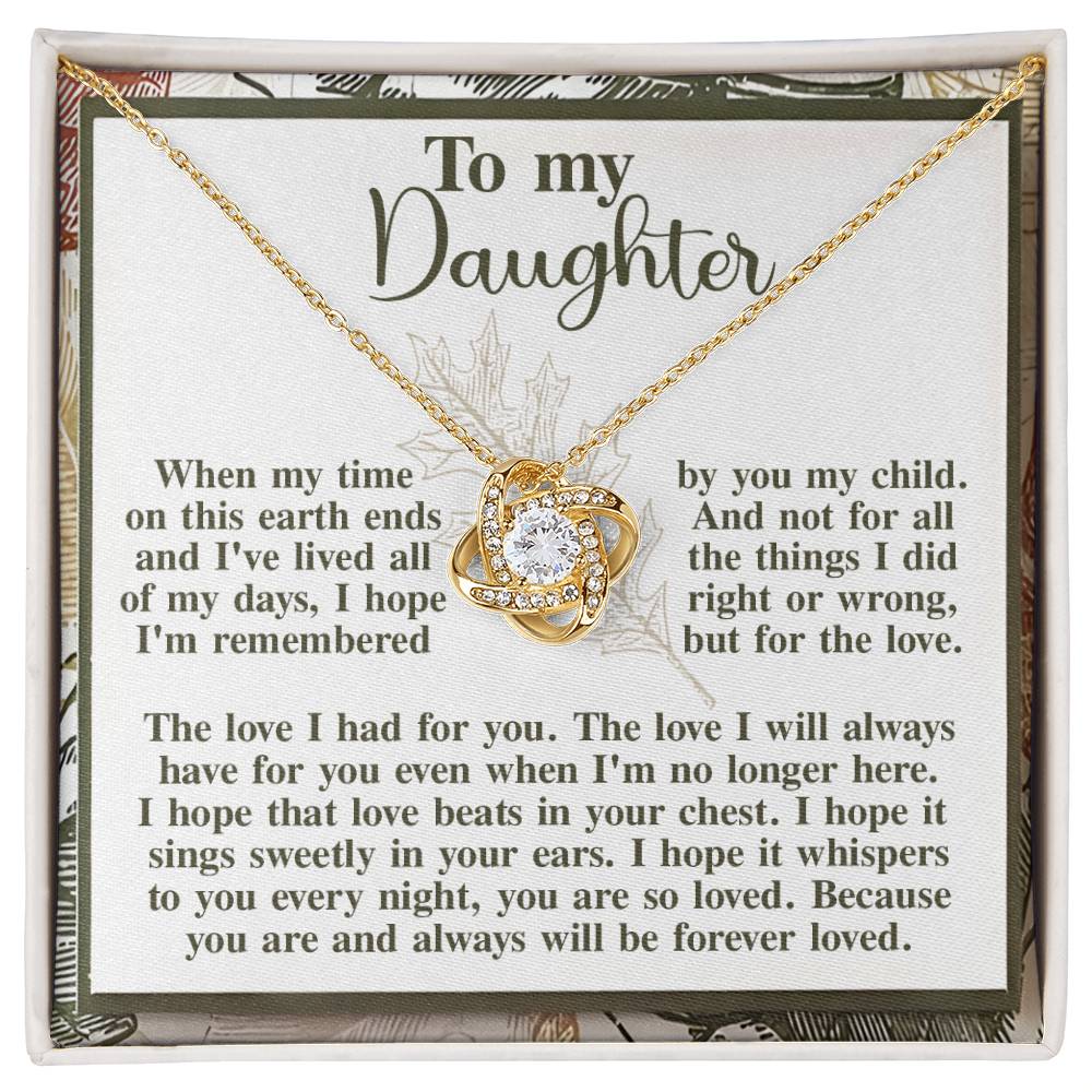 The "Daughter-In Your Ears - Love Knot Necklace" in a yellow gold finish, featuring a heart-shaped crystal made of cubic zirconia crystals, is beautifully displayed on a card with the title "To my Daughter" and a heartfelt message about love and remembrance.