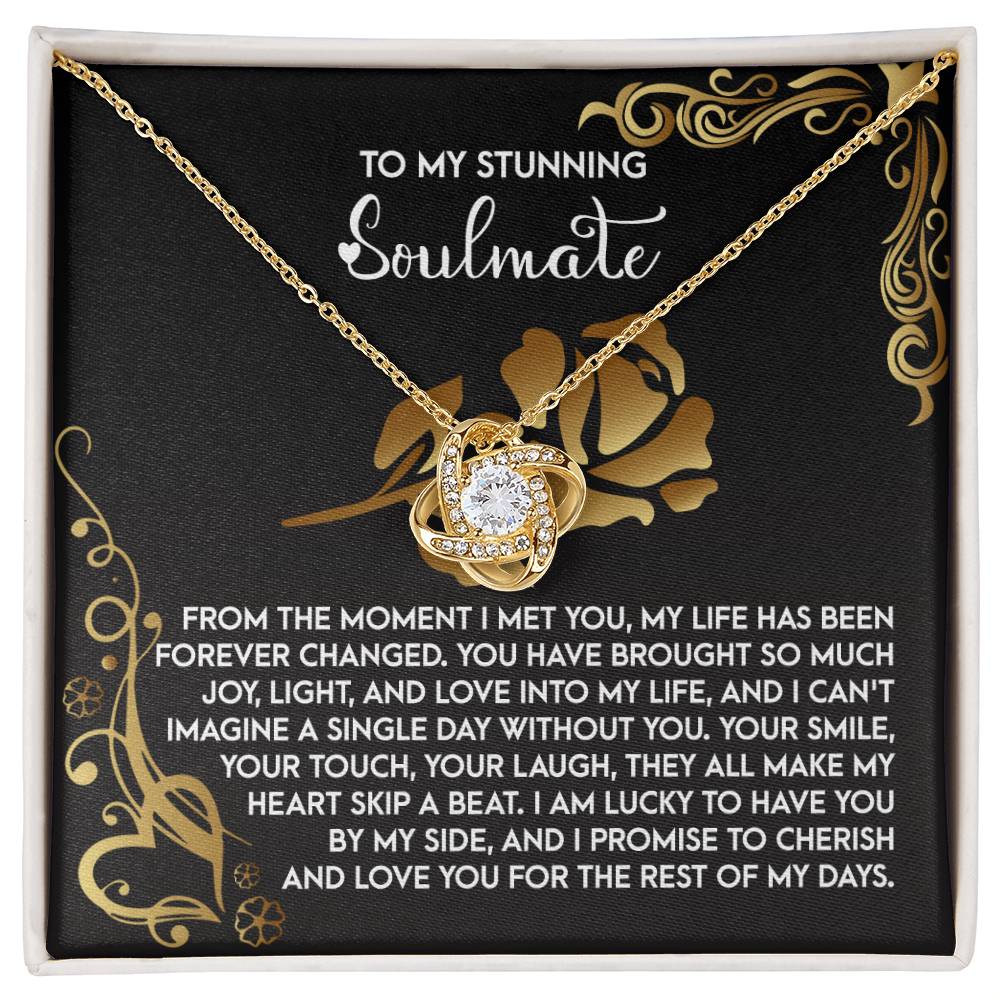 The Soulmate-I Met You 2 - Love Knot Necklace features a circular pendant adorned with cubic zirconia, available in white or yellow gold finishes. It comes in a decorative box with the words "To my stunning soulmate," followed by a romantic message.