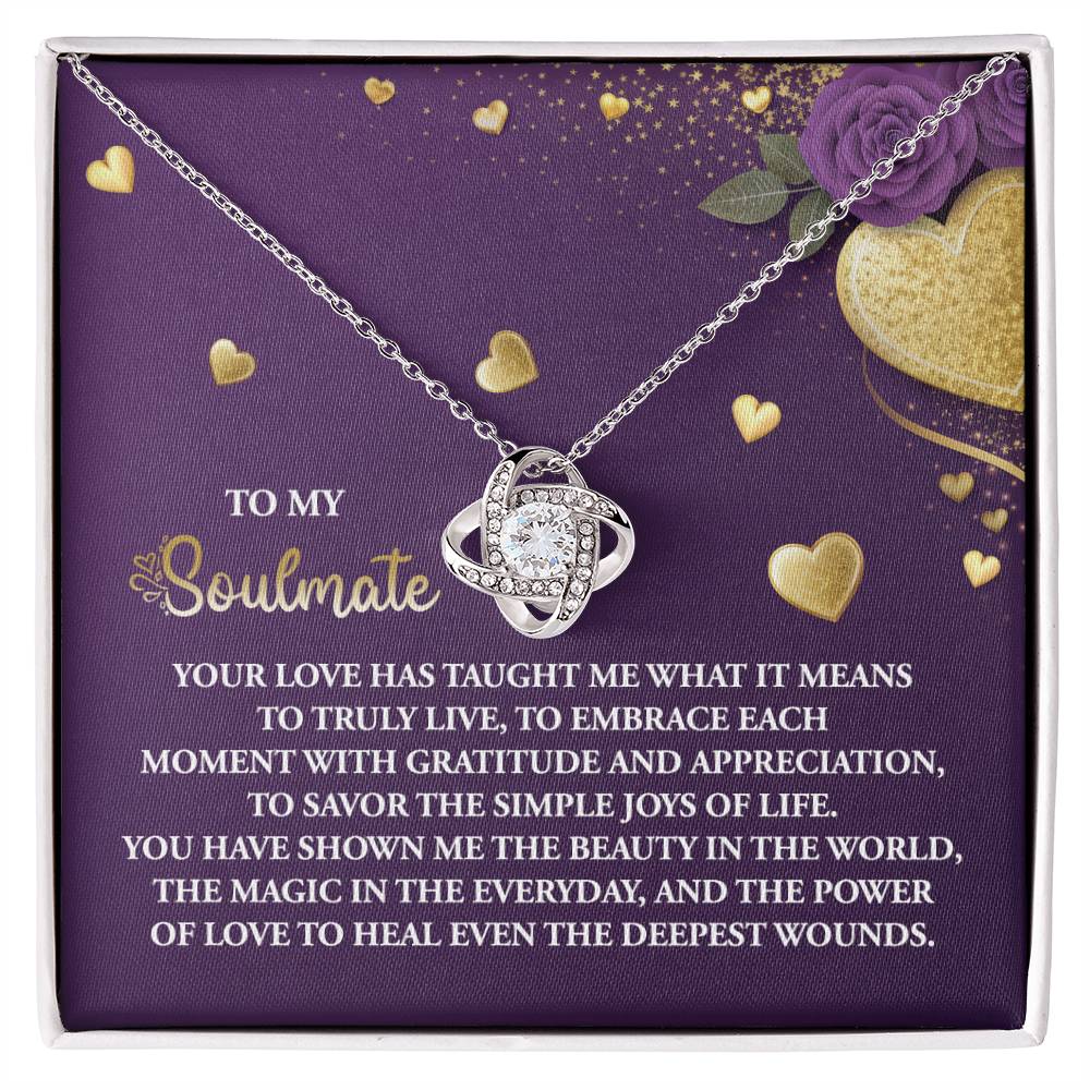 The Soulmate-Joys Of Life Love Knot Necklace features interlocking rings on a purple background with gold heart accents and cubic zirconia crystals, crafting a beautiful testament to love and soulmates. It's the perfect personalized gift for that special someone.