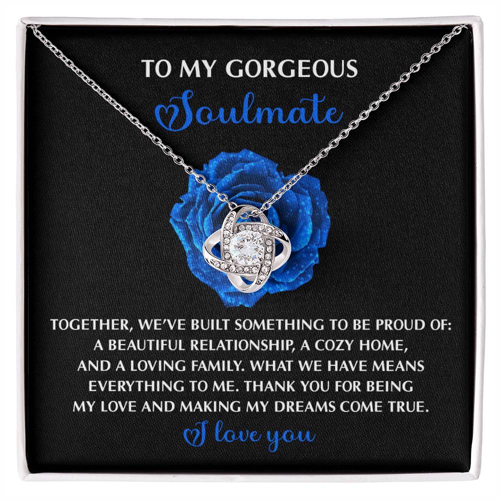 The Soulmate-Dreams Come True - Love Knot Necklace features cubic zirconia set in white gold, displayed on a card with a heartfelt message to a soulmate against a blue rose background.