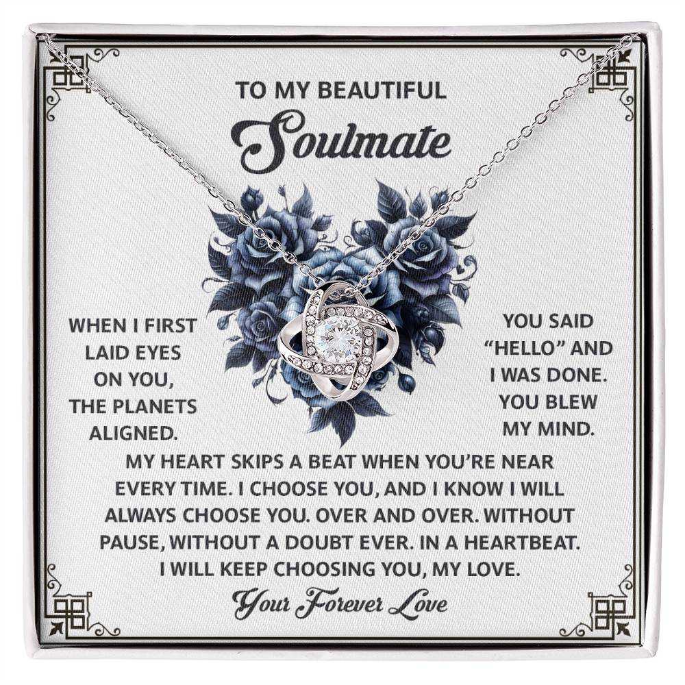 The Soulmate-Skips A Beat - Love Knot Necklace features cubic zirconia crystals intertwined elegantly on a card with a heartfelt message for a "beautiful soulmate," expressing love and devotion, making it the perfect personalized gift.