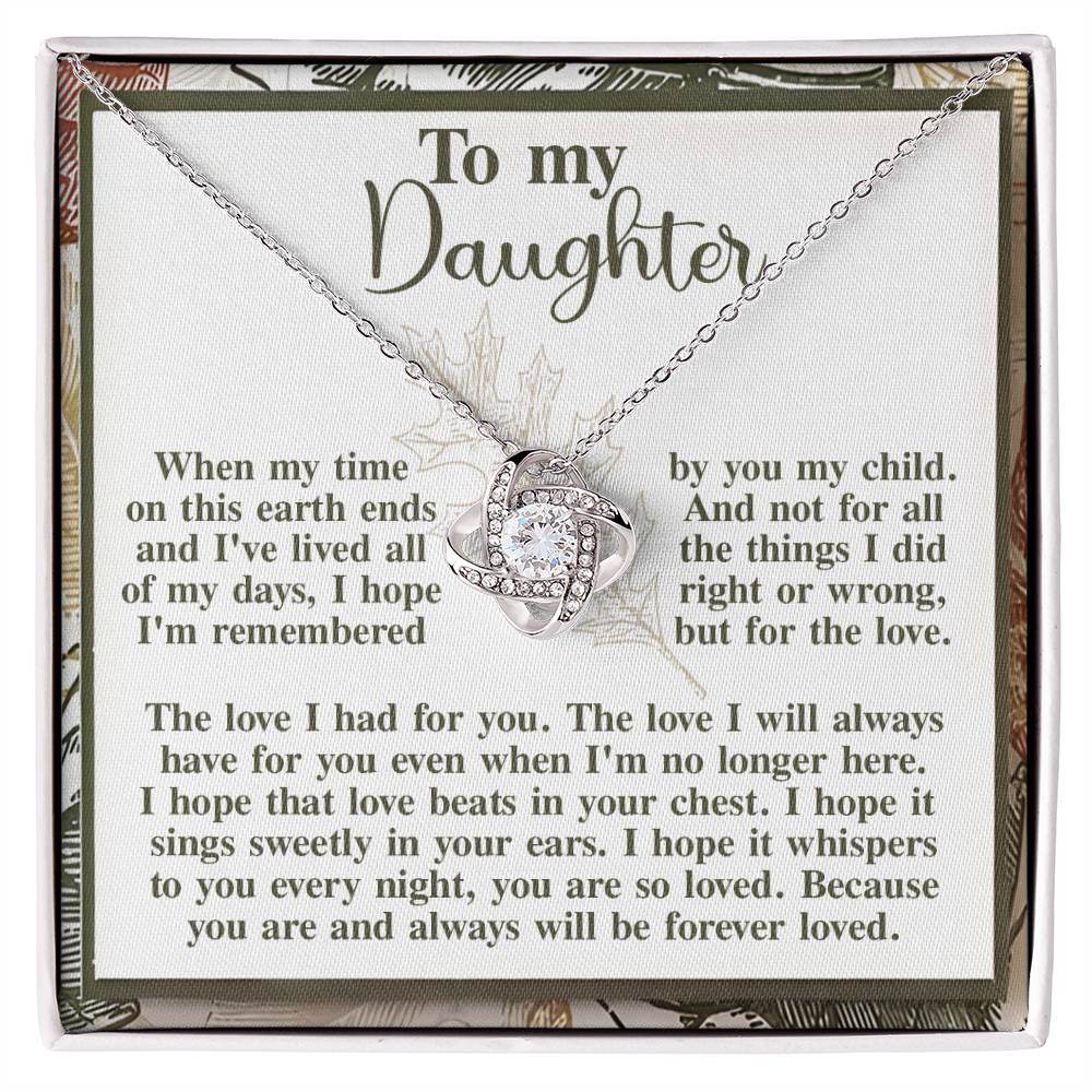 A Daughter-In Your Ears - Love Knot Necklace featuring an interlocking heart pendant is showcased against a card reading, "To my Daughter," accompanied by a heartfelt message about everlasting love and remembrance. Adorned with shimmering cubic zirconia crystals, it makes for an exceptionally personalized gift.