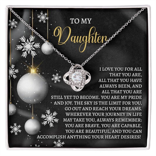 The Daughter-Pride And Joy - Love Knot Necklace features a heart-shaped pendant set against a snowflake background. It includes the text, "To my Daughter," along with an inspirational message about love, pride, and encouragement to follow her dreams. Personalized and adorned with cubic zirconia, this keepsake is a timeless treasure she'll always cherish.