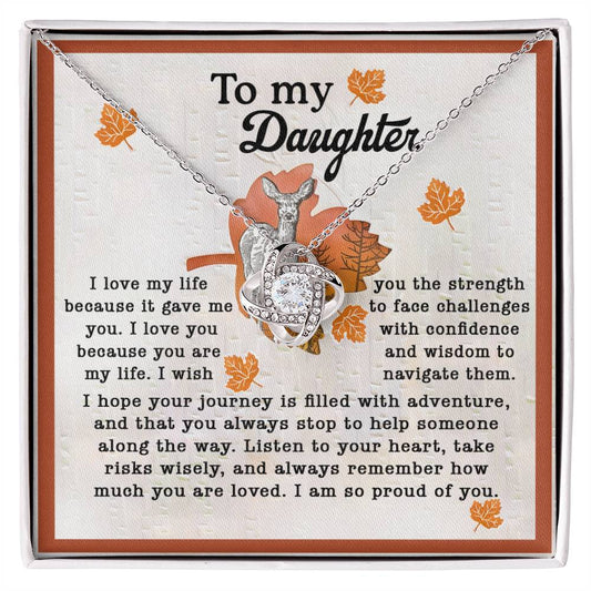 A silver Daughter-Gave Me You - Love Knot Necklace featuring an intertwined heart pendant adorned with cubic zirconia crystals is displayed on a card that reads, "To my Daughter" and includes a heartfelt message expressing pride, love, strength, and guidance for her life's journey.