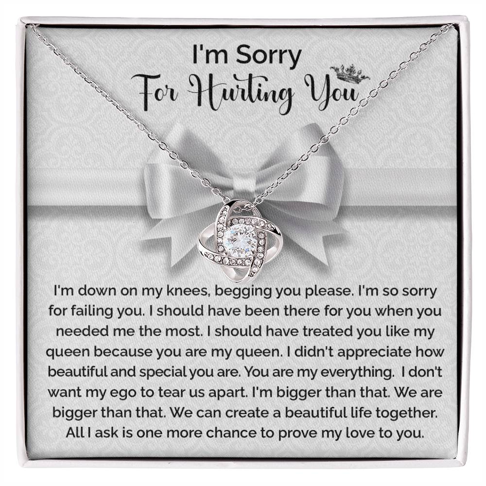 The "Sorry-My Queen - Love Knot Necklace" features a knot-shaped pendant adorned with cubic zirconia crystals and comes in a gift box that includes an apology message, expressing regret and asking for forgiveness and another chance to prove love.