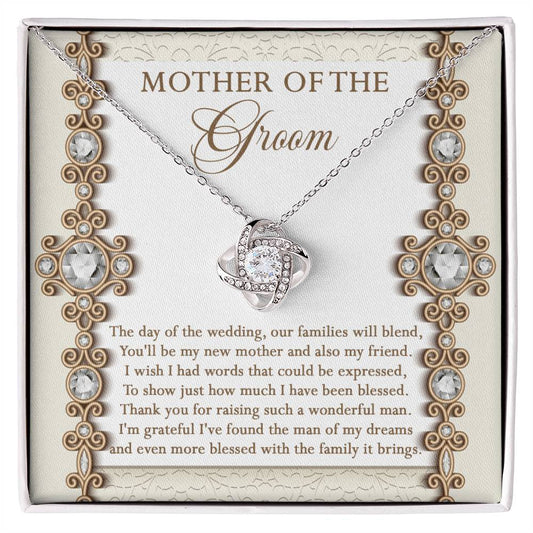 To Mom Of Groom, New Mother - Love Knot Necklace with an interlocking heart pendant, adorned with cubic zirconia crystals, on a card reading: “Mother of the Groom” and a heartfelt message appreciating the groom's mother. Available in white gold or yellow gold finish.