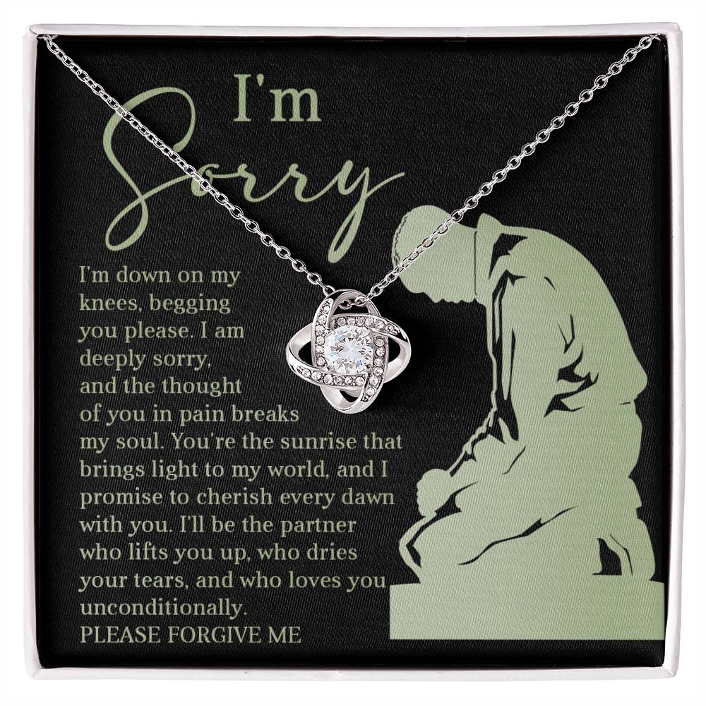 Box containing the "Sorry-On My Knees - Love Knot Necklace," adorned with cubic zirconia crystals and featuring a heartfelt message that reads, "I'm sorry. I'm down on my knees, begging you please. I am deeply sorry. Please forgive me.