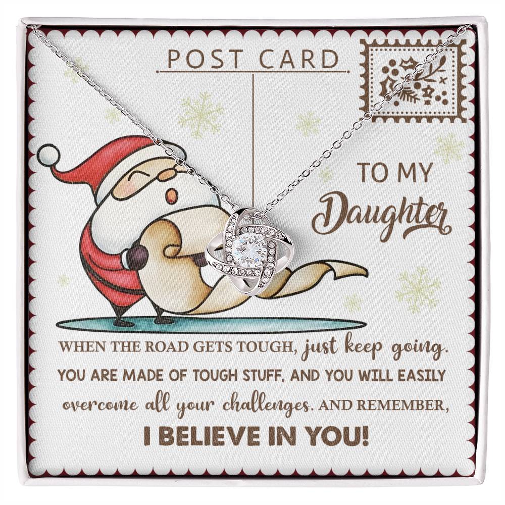 The Daughter-Keep Going - Love Knot Necklace, showcasing an intertwined design, is presented on a card adorned with Santa and an encouraging message for a daughter. This elegant piece is available in either White Gold or Yellow Gold Finish and sparkles with Cubic Zirconia Crystals.