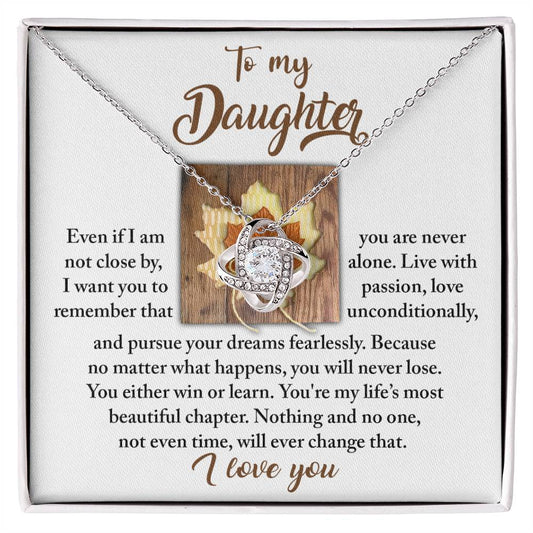 The Daughter-Live With Passion Love Knot Necklace, featuring an intertwined knot design adorned with cubic zirconia crystals, is presented alongside a heartfelt message from a parent to their daughter, encouraging her to live passionately and fearlessly while expressing eternal love.