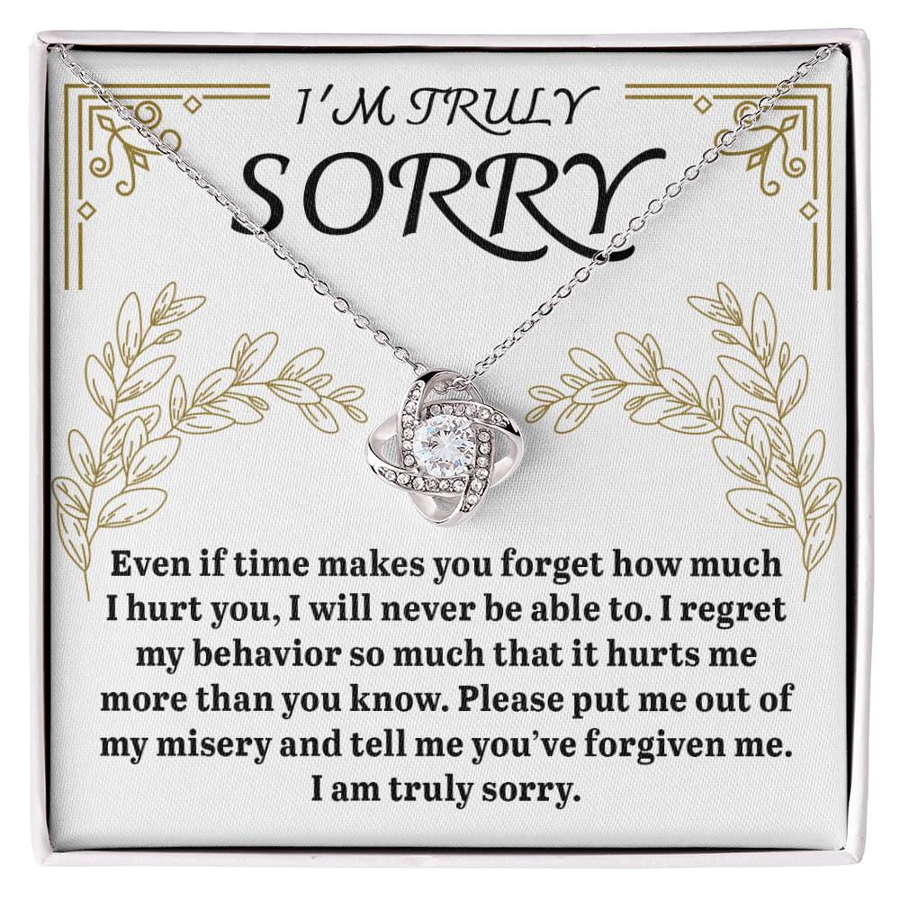 The Sorry-It Hurts Me Love Knot Necklace, crafted from 14k white gold and featuring a heart pendant, is beautifully presented in a box with the message "I'm truly sorry," along with a heartfelt apology expressing regret and seeking forgiveness.