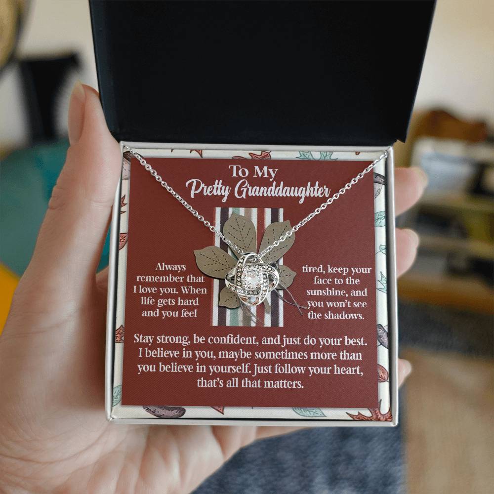 The Granddaughter-See The Shadows - Love Knot Necklace is expertly designed in 14k White Gold with an elegant arrangement of Cubic Zirconia, and it comes beautifully packaged in a box. The accompanying card reads: "To My Pretty Granddaughter" and contains an inspirational message. This necklace features a circular intertwined design, representing eternal love and connection.