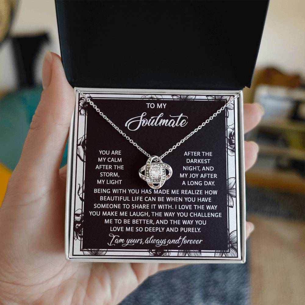 A box containing the Soulmate-Deeply And Purely - Love Knot Necklace with cubic zirconia crystals is accompanied by a card titled "To my soulmate," featuring a heartfelt message about our unbreakable bond, love, joy, and appreciation.