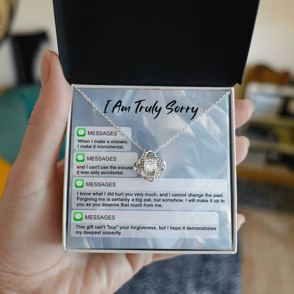 The "Sorry, Make A Mistake - Love Knot Necklace" adorned with cubic zirconia crystals, placed over a background card that reads "I Am Truly Sorry" and includes a series of apology text messages, is the perfect personalized gift for heartfelt apologies.