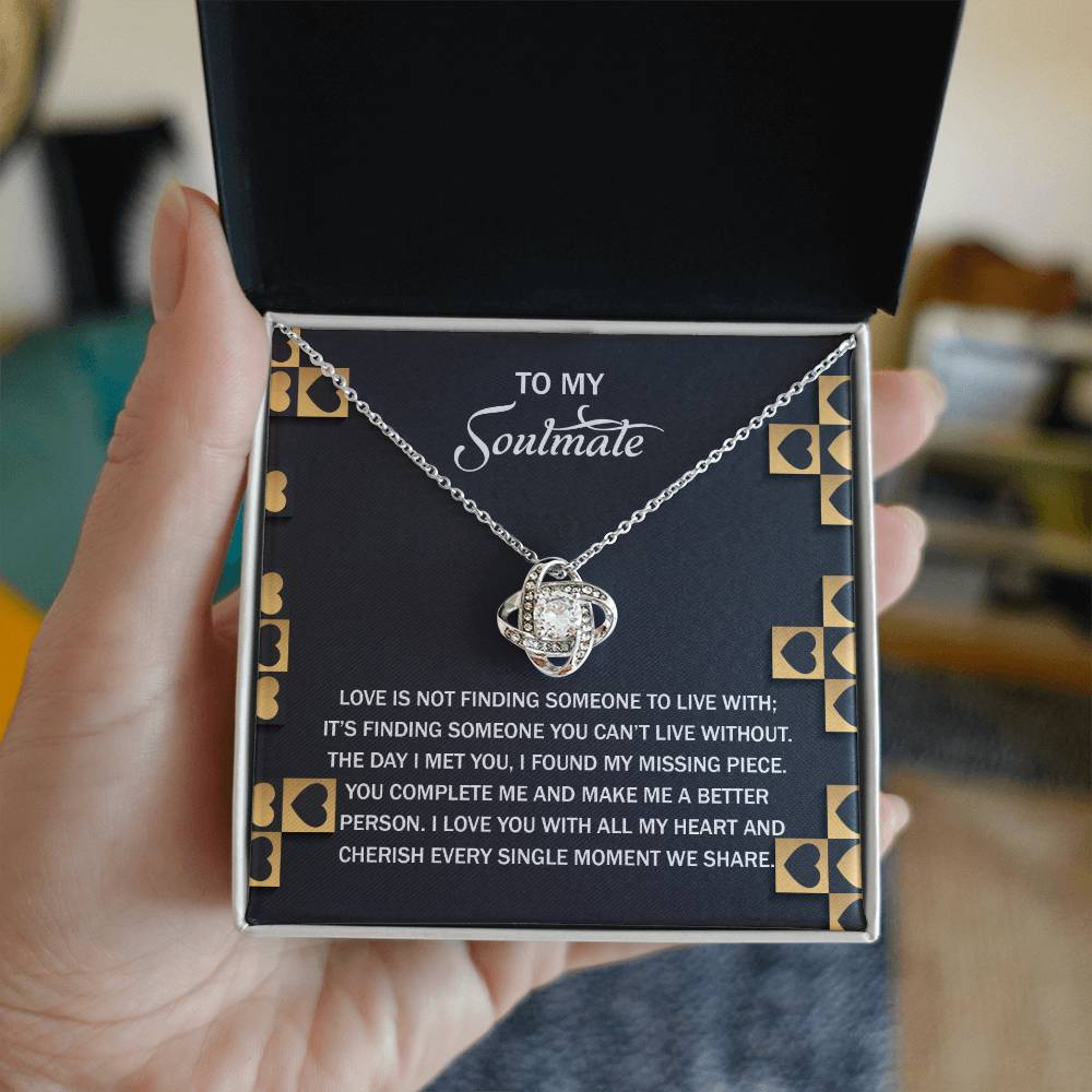 The open gift box reveals a stunning Soulmate-Missing Piece - Love Knot Necklace with an elegantly entwined pendant. Finished in gold, it sparkles with cubic zirconia accents, perfectly paired with a romantic message about soulmates and love.