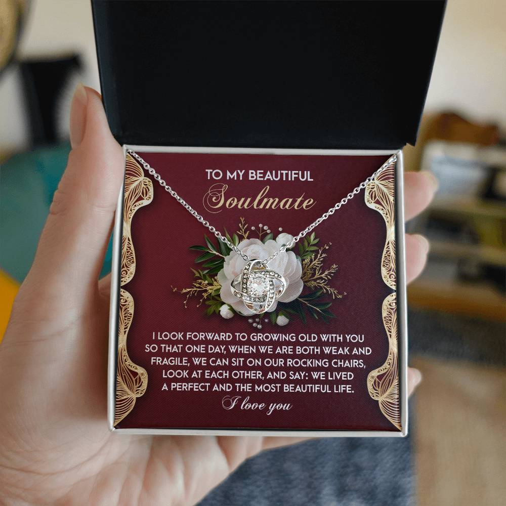The Soulmate-Rocking Chairs - Love Knot Necklace is a personalized gift in a floral design box, featuring shimmering cubic zirconia crystals and a heartfelt message titled "To My Beautiful Soulmate," expressing love and the wish to grow old together.