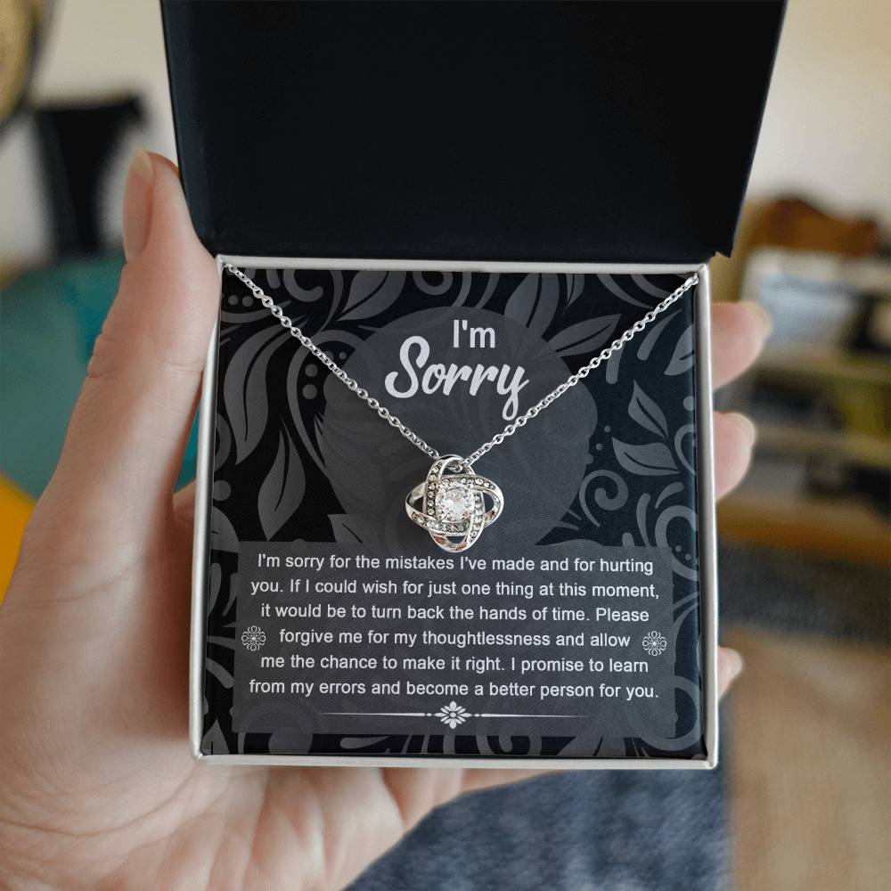 The Sorry-Just One Thing - Love Knot Necklace with intertwined loops is elegantly displayed in a box, featuring an apology message on the inside lid that reads: "I'm sorry. I'm sorry for the mistakes I've made and for hurting you...