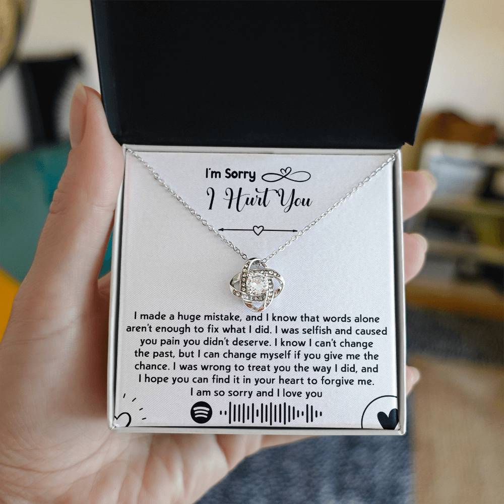 The "Sorry-You Didn't Deserve - Love Knot Necklace" features an intertwined heart pendant adorned with cubic zirconia crystals and a gold finish, beautifully presented in a box with a heartfelt apology message. The message conveys deep regret, asks for forgiveness, and promises to change.