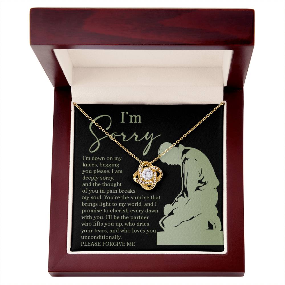 The Sorry-On My Knees - Love Knot Necklace comes presented in a jewelry box with an apology note featuring a heartfelt message, an illustration of a kneeling person, and the phrase "I'm Sorry" prominently displayed. This personalized gift is beautifully adorned with sparkling cubic zirconia crystals.