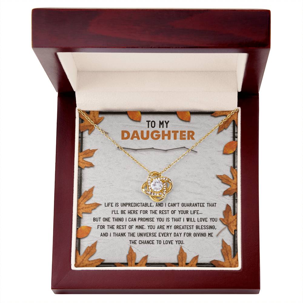 The Daughter-My Greatest Blessing - Love Knot Necklace features a round pendant adorned with cubic zirconia crystals and comes in a wooden box. The interior is decorated with leaves and includes the heartfelt message, "To My Daughter," along with an inspirational note celebrating your unbreakable bond.