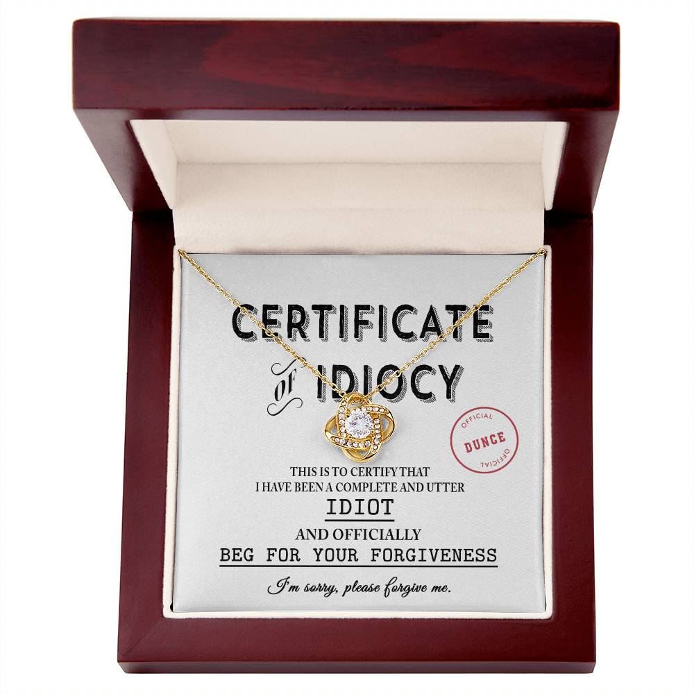 A Sorry-Certificate Of Idiocy featuring a Love Knot Necklace adorned with cubic zirconia crystals, elegantly presented in a red box.