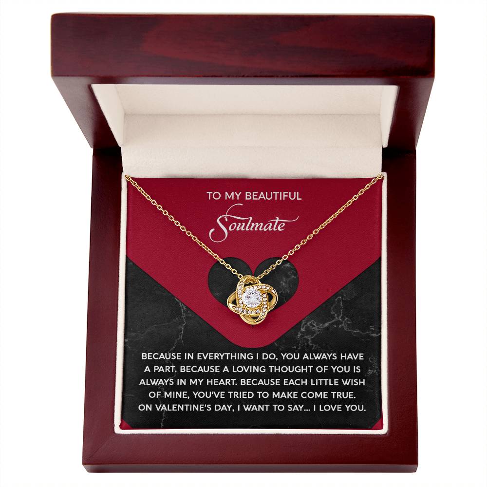 The Soulmate-Loving Thought - Love Knot Necklace, adorned with cubic zirconia crystals, is elegantly showcased in an open wooden box. The interior features a heart design and romantic message for a "soulmate," making it the perfect personalized gift.