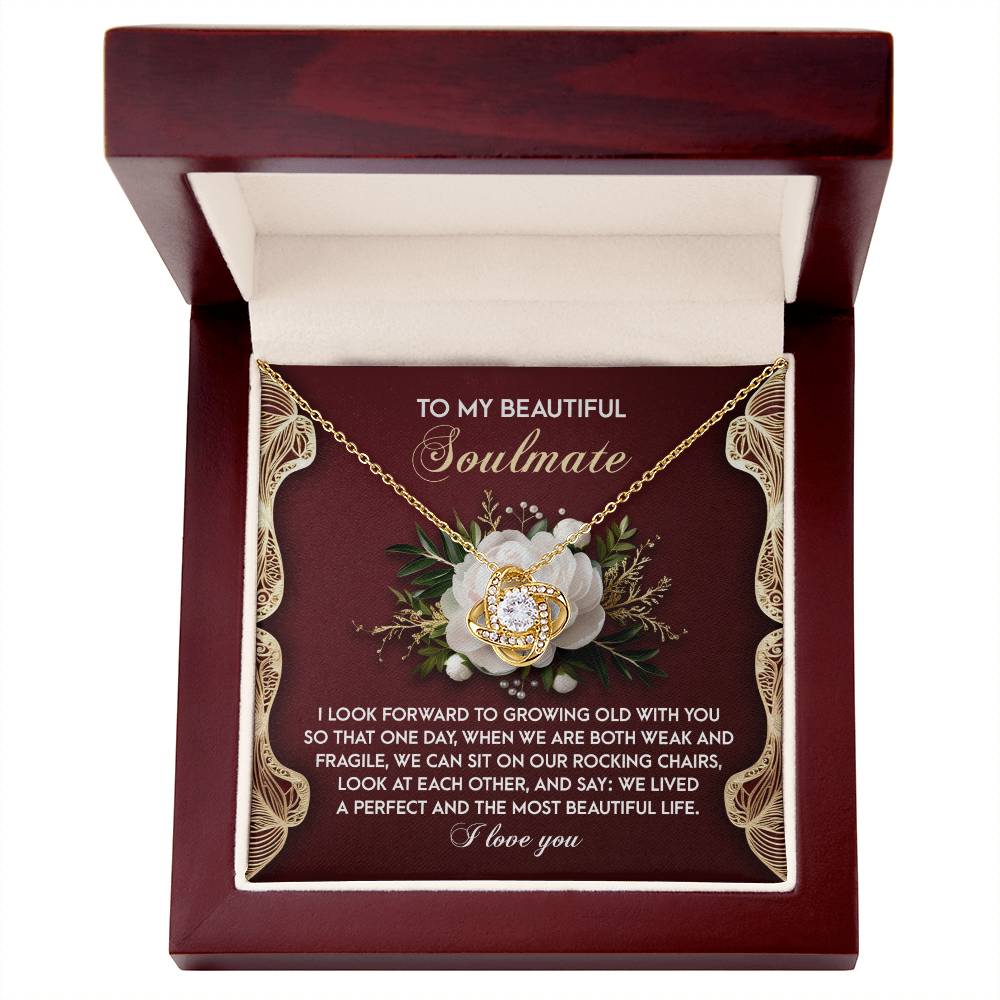 Open a box containing the Soulmate-Rocking Chairs - Love Knot Necklace on a floral card. It includes a heartfelt message for a "Beautiful Soulmate," making it an ideal personalized gift adorned with cubic zirconia crystals.