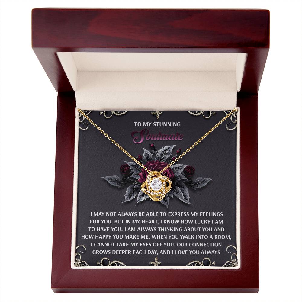 The Soulmate-Eyes Off You - Love Knot Necklace, with its heart pendant and shimmering cubic zirconia adorned in a delicate white gold finish, rests elegantly in an open wooden box displaying a romantic message inside. It captures timeless love and elegance.