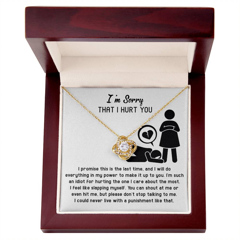The Sorry-Stop Talking - Love Knot Necklace is displayed in an open wooden box, adorned with Cubic Zirconia Crystals and accompanied by a heartfelt apology message about regret and the desire to make amends.