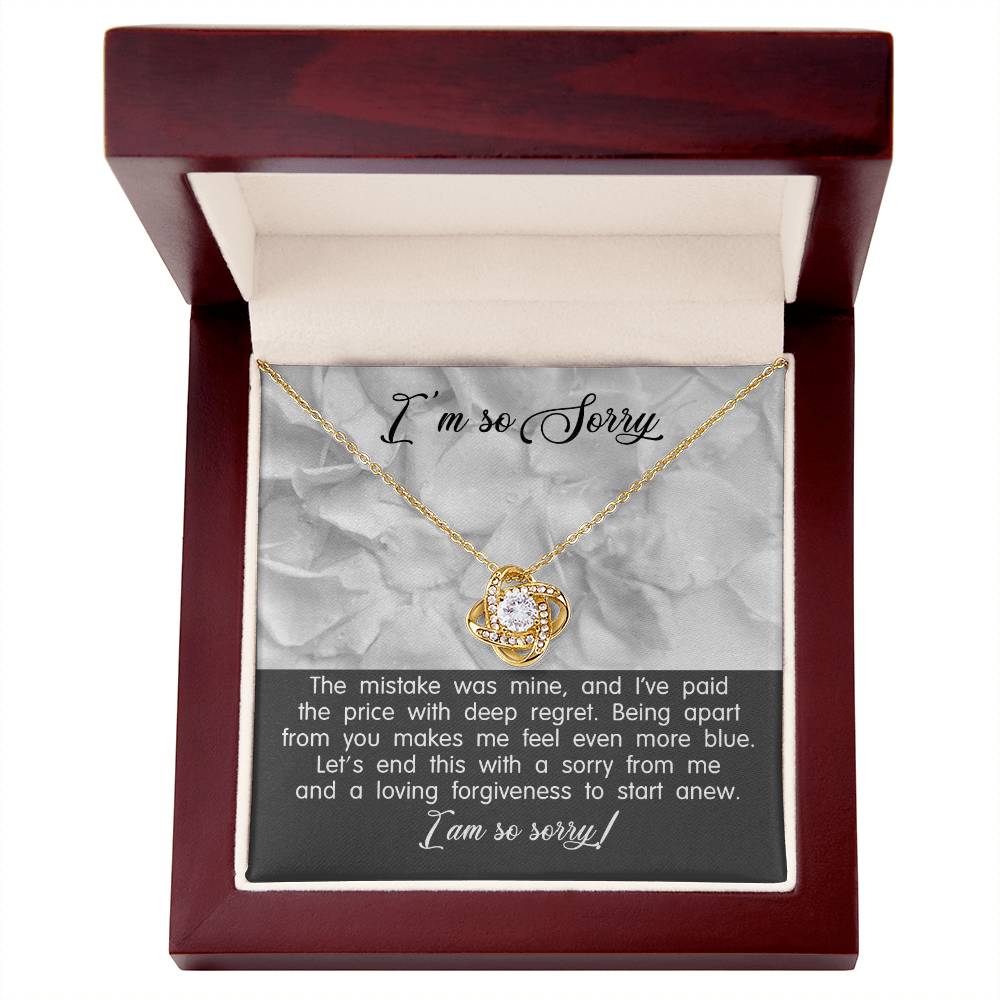 The product "Sorry-With Deep Regret - Love Knot Necklace" features an open jewelry box with a gold Love Knot Necklace adorned with cubic zirconia crystals inside. The inside lid reads "I’m so Sorry," and the box includes an apology message expressing regret and a wish for forgiveness, making it the perfect personalized gift.