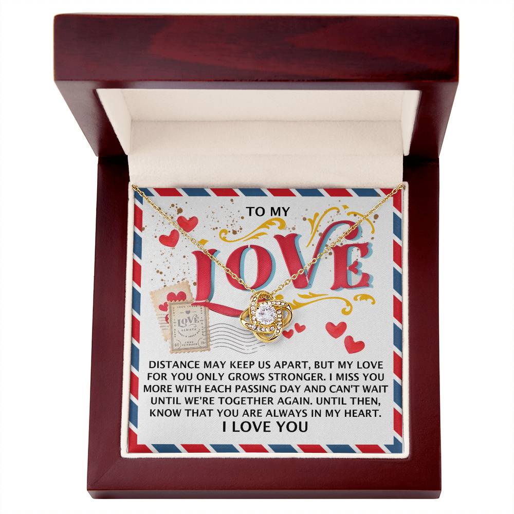 The Soulmate-In My Heart - Love Knot Necklace, featuring a heart-shaped pendant in 14k white gold with cubic zirconia crystals, is presented in an open wooden box with a lid inscribed with a romantic message about love and missing someone.