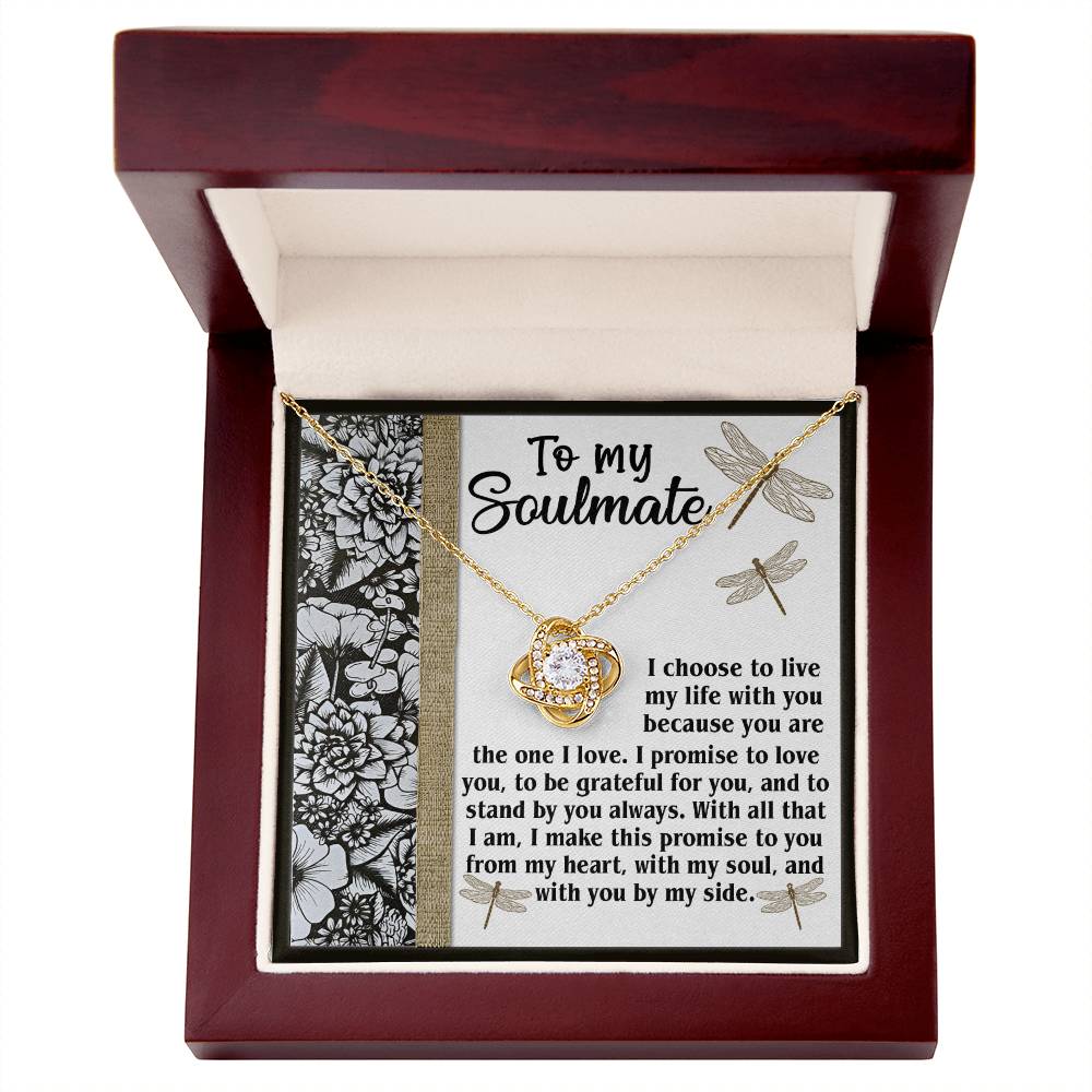 Introducing the Soulmate-Make This Promise - Love Knot Necklace: a stunning piece featuring a circular pendant adorned with cubic zirconia crystals. It comes elegantly displayed in a wooden box, which also includes a heartfelt card that reads, "To my Soulmate," accompanied by a floral decoration.