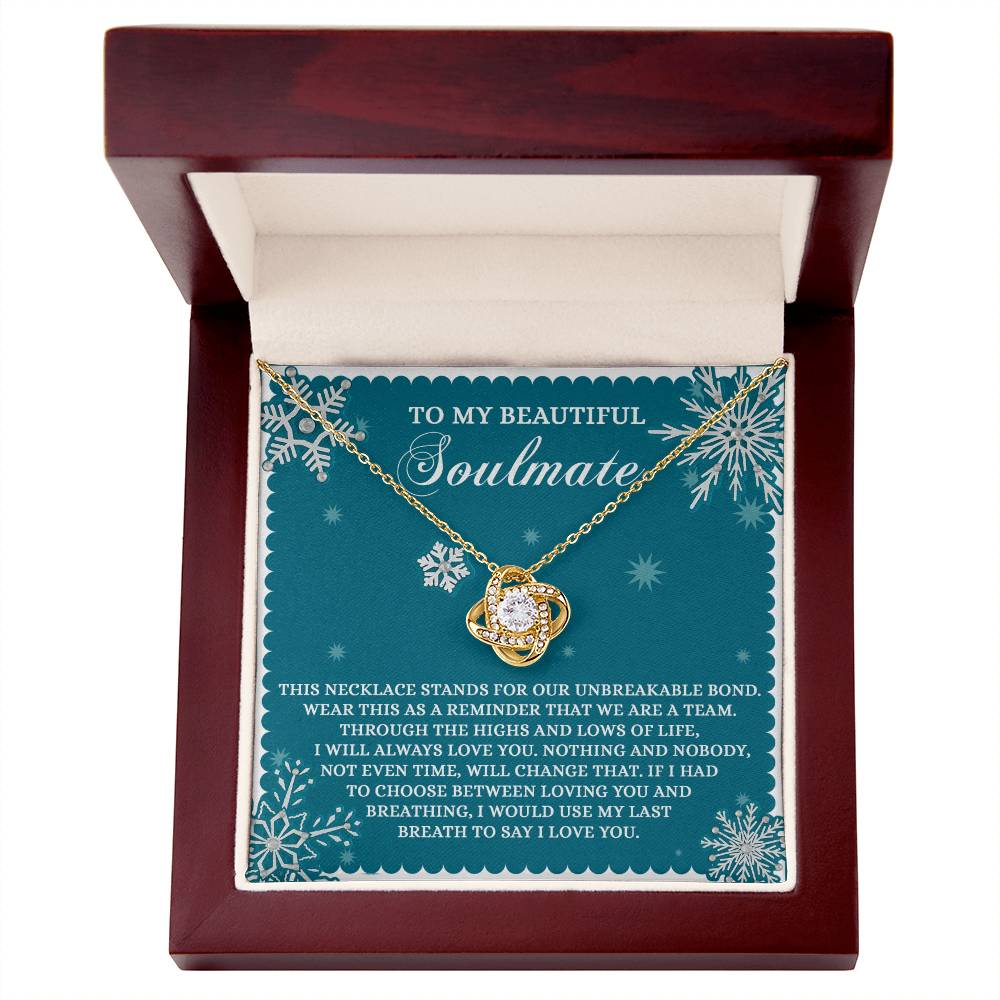 The Soulmate-A Team - Love Knot Necklace, crafted in gold and silver, is beautifully presented in an open wooden box. Inside the lid, a heartfelt message about love and soulmates is etched, symbolizing an unbreakable bond. This personalized gift is perfect for celebrating lifelong connections.