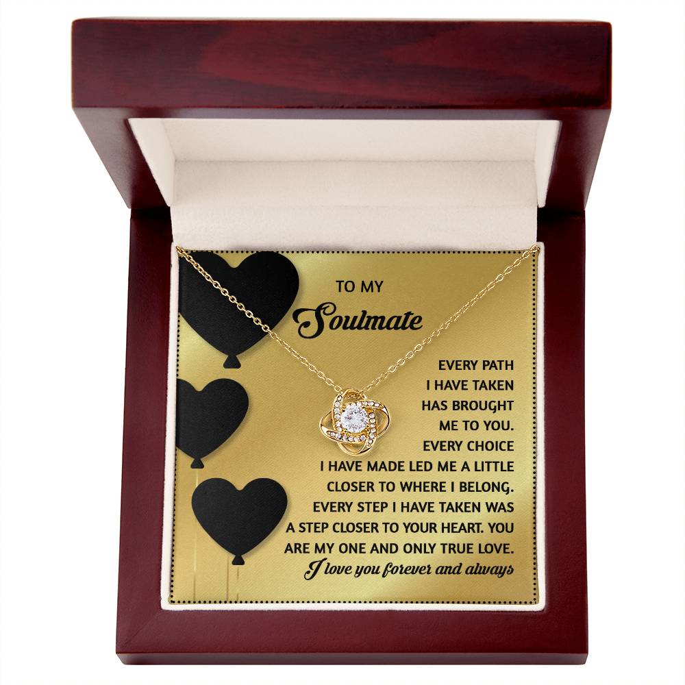The Soulmate-A Step Closer - Love Knot Necklace, embellished with cubic zirconia crystals, comes in an open wooden box. Inside the lid is a heartfelt message to a soulmate with black heart designs, making it an ideal personalized gift.