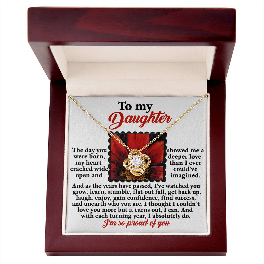The Daughter-A Deeper Love - Love Knot Necklace, adorned with premium cubic zirconia crystals and featuring a heart pendant, is elegantly presented in an open gift box that contains a heartfelt message to a daughter inscribed inside.