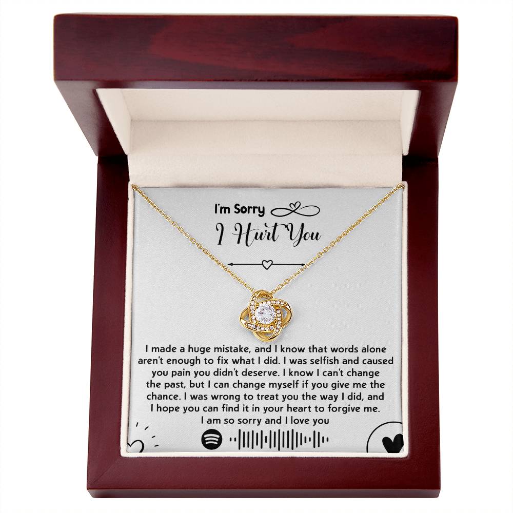 The "Sorry-You Didn't Deserve - Love Knot Necklace" featuring premium cubic zirconia crystals is presented in a red box. Included is an apology note expressing sincere regret and asking for forgiveness, with the front reading, "I'm Sorry I Hurt You." This personalized gift aims to mend hearts and convey heartfelt apologies.