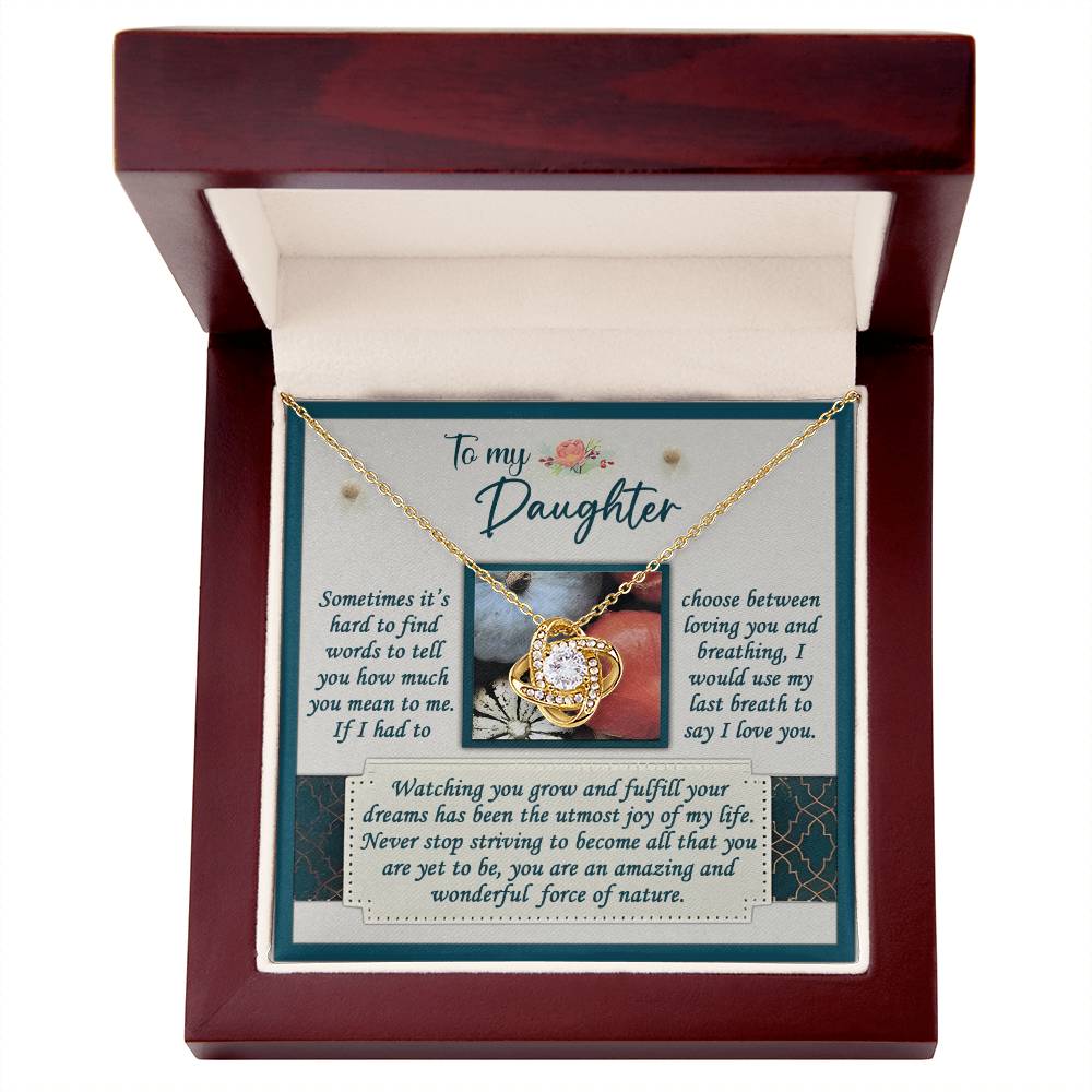 A Daughter-Force Of Nature Love Knot Necklace in a wooden box with a message card for a daughter, adorned with cubic zirconia crystals and conveying a heartfelt message about love and admiration.
