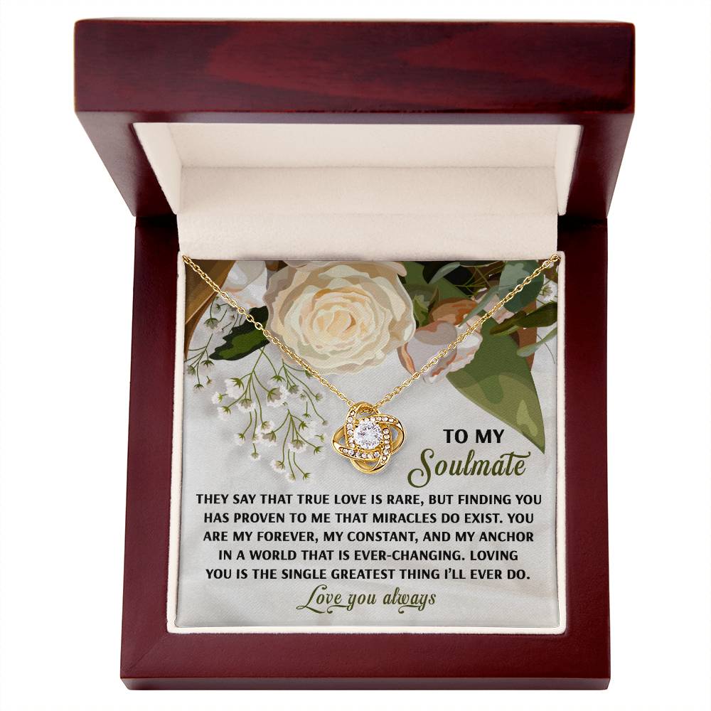 The Soulmate-Greatest Thing - Love Knot Necklace showcases a central stone with cubic zirconia crystals. It comes in a wooden box adorned with floral graphics and the message "To My Soulmate," providing an elegantly personalized and sentimental gift.