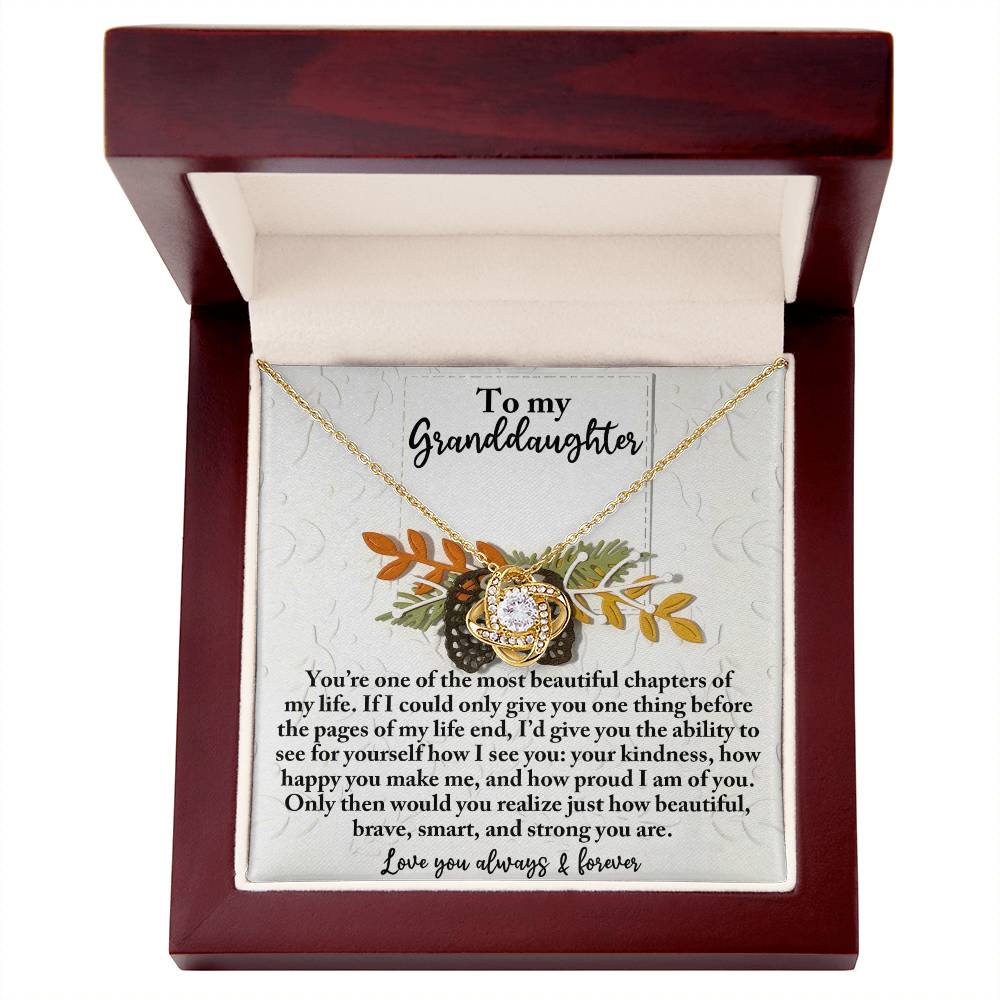 The Granddaughter-How Beautiful - Love Knot Necklace, embellished with Cubic Zirconia Crystals, is presented in a wooden gift box with a touching "To my Granddaughter" message engraved inside, creating the ideal personalized gift.