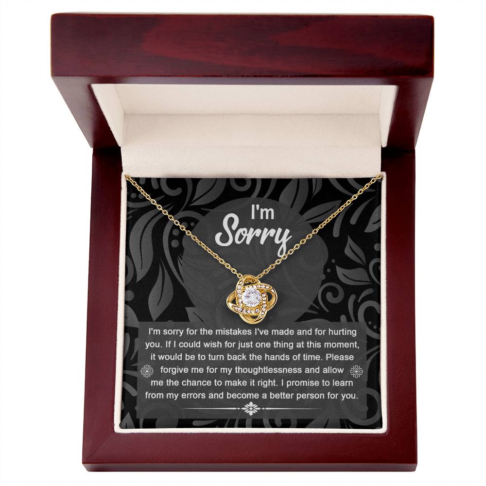 Displayed in a wooden box, the Sorry-Just One Thing - Love Knot Necklace serves as a personalized gift. Inside the lid, an apology message expresses regret, seeks forgiveness, and promises to be a better person. The pendant features elegant cubic zirconia crystals, making this heartfelt gesture even more special.
