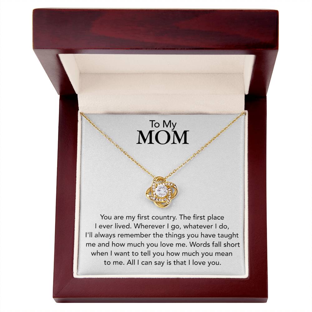 A To My Mom, You Are My First Country - Love Knot Necklace with cubic zirconia crystals and a heart design, presented in a mahogany jewelry box with an inscription for "mom" expressing love and appreciation by ShineOn Fulfillment.