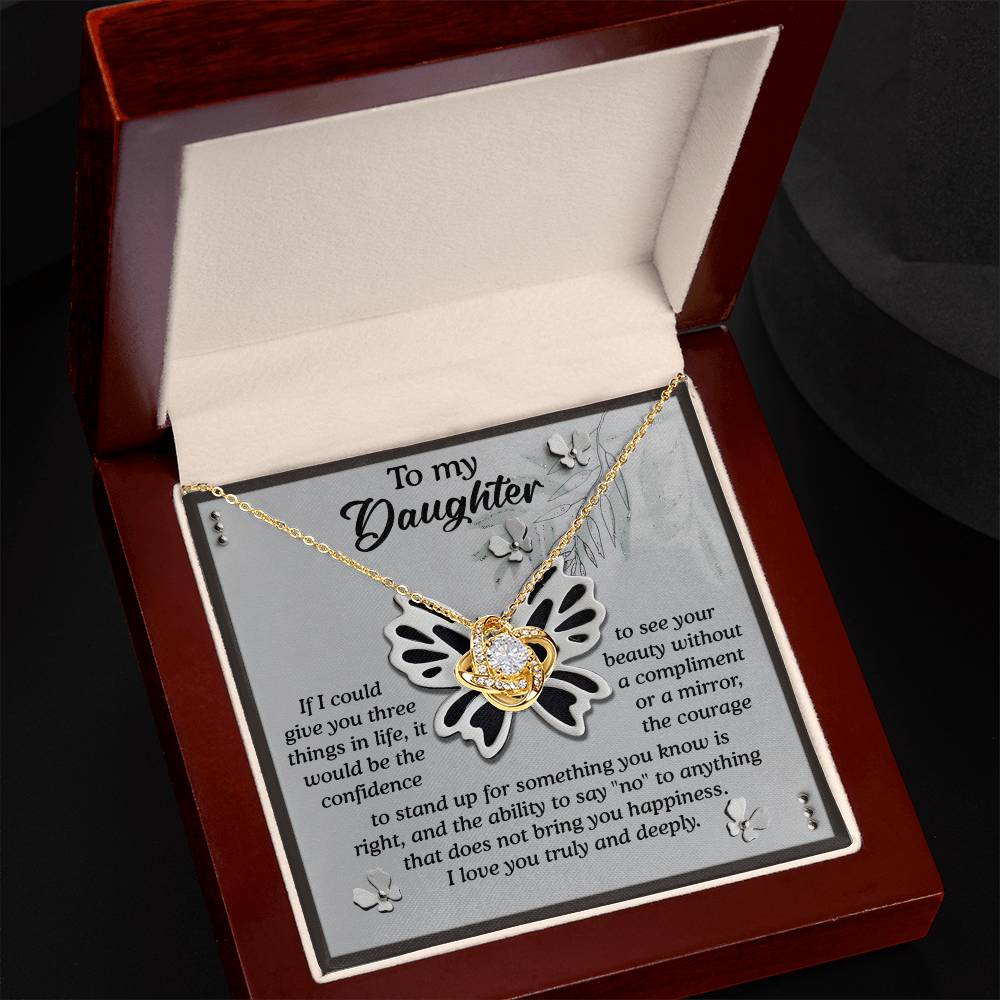 The Daughter-See Your Beauty - Love Knot Necklace, featuring a butterfly pendant in a white gold finish, rests in an open jewelry box. Inside the lid, a sentimental message to a daughter is printed, and premium cubic zirconia crystals add a touch of elegance.