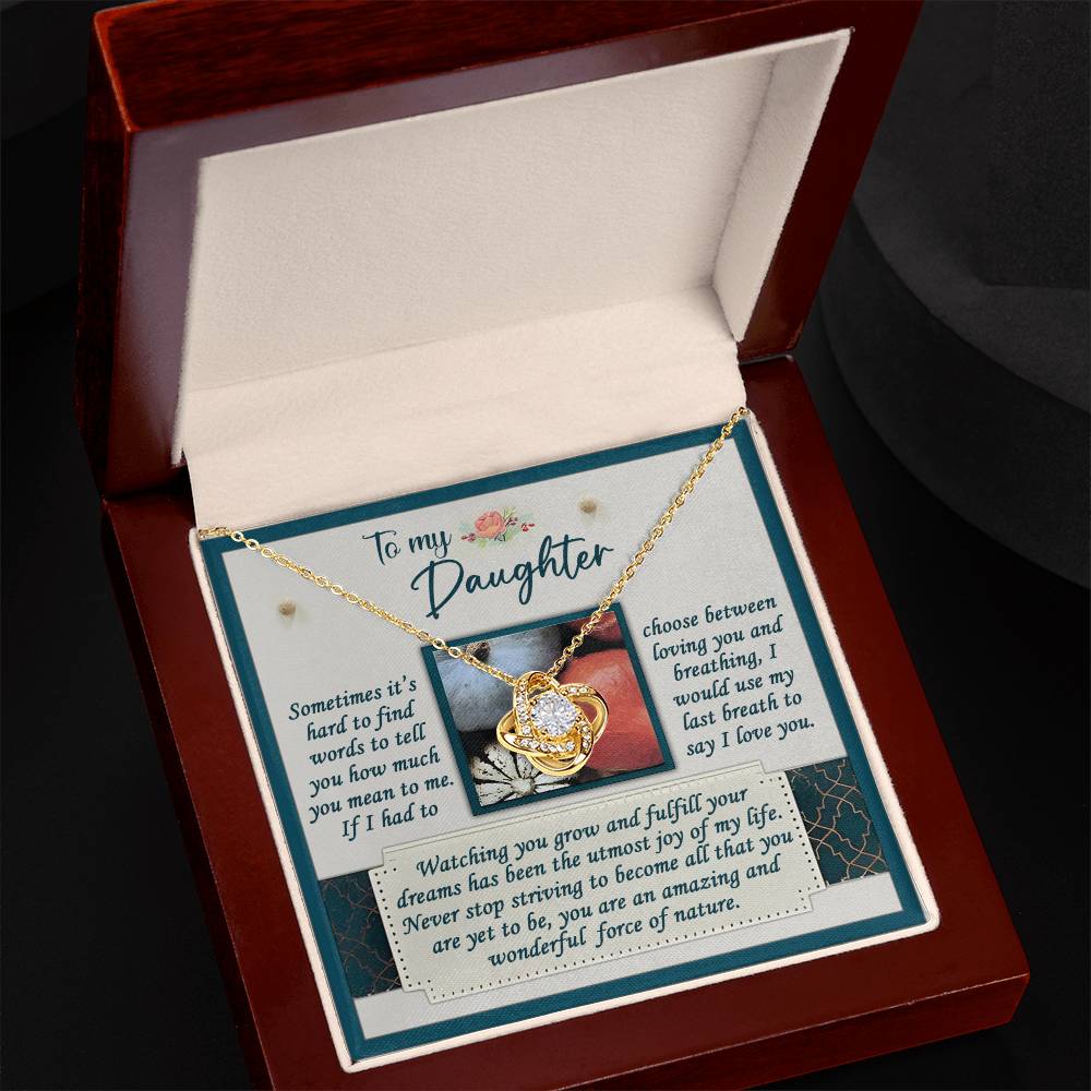 The Daughter-Force Of Nature - Love Knot Necklace rests in an open box, adorned with sparkling cubic zirconia crystals and featuring a heartfelt inscription to a daughter.