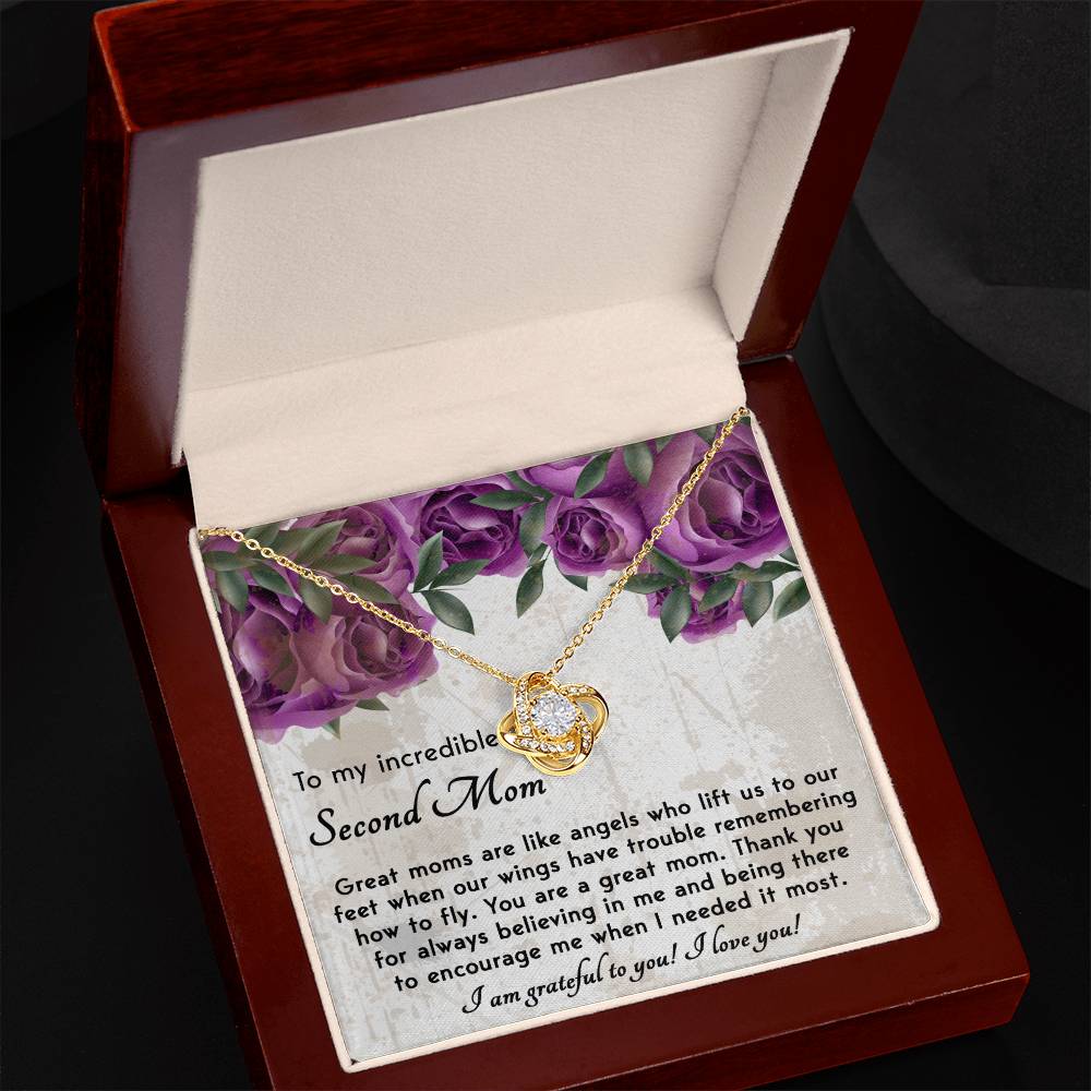 A personalized gift, this "To Bonus Mom, Grateful For You - Love Knot Necklace" with a heart pendant is beautifully displayed in an open box. It features a heartfelt message to a "Bonus Mom" against a floral background and is adorned with sparkling cubic zirconia crystals.