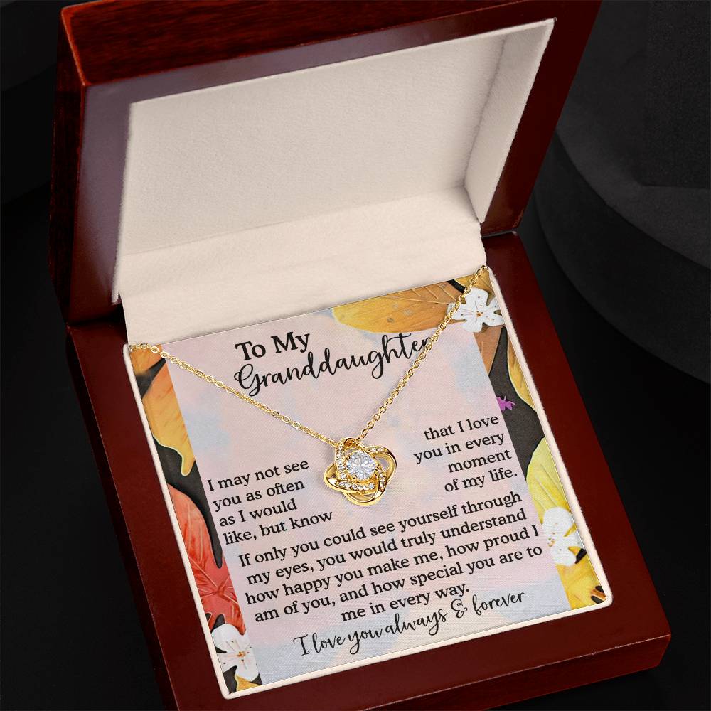 The Granddaughter-In Every Way - Love Knot Necklace features a heart pendant crafted from 14k White Gold and adorned with Cubic Zirconia Crystals, elegantly displayed in a box with a heartfelt message for a granddaughter.