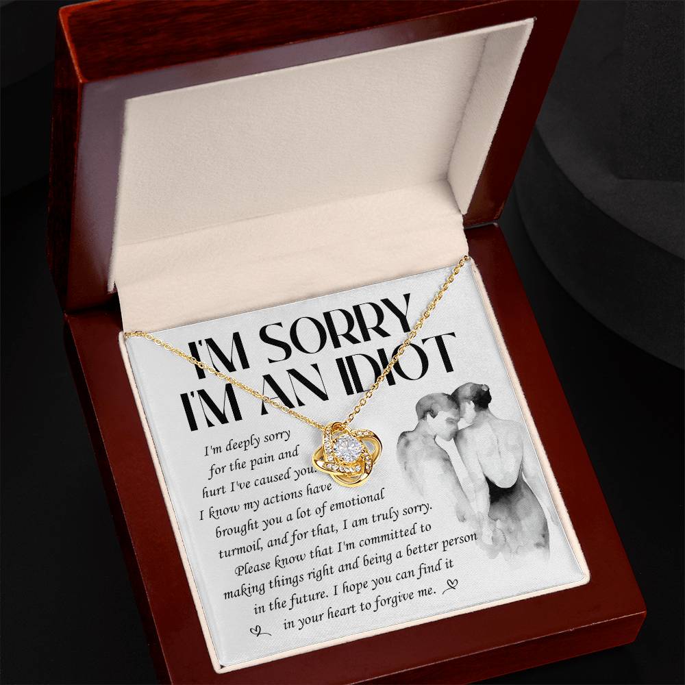 The Sorry-Emotional Turmoil - Love Knot Necklace comes with an intertwined heart and ribbon pendant adorned with sparkling cubic zirconia crystals, presented inside a wooden gift box. The box’s lid features an apology letter alongside a drawing of a couple embracing, making it the perfect personalized gift.