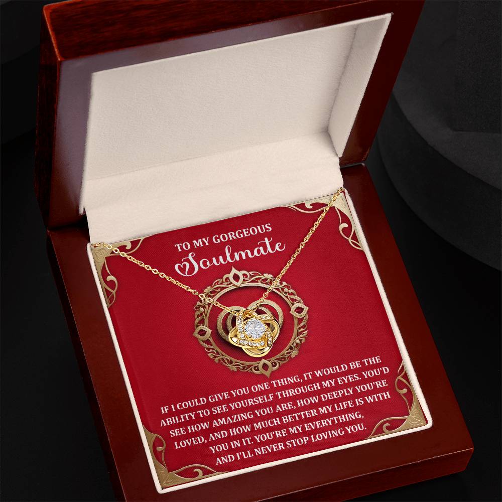The Soulmate-Through My Eyes Love Knot Necklace features linked hearts and a central cubic zirconia crystal, elegantly boxed. The background reads, "To my gorgeous soulmate," with a heartfelt message—an exquisite personalized gift for your loved one.