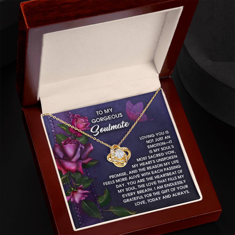 The Soulmate-Unspoken Promise - Love Knot Necklace features a heart-shaped pendant with shimmering cubic zirconia crystals, presented in a wooden box. It comes with a card adorned with purple roses and a romantic message, making it an elegant and personalized gift.