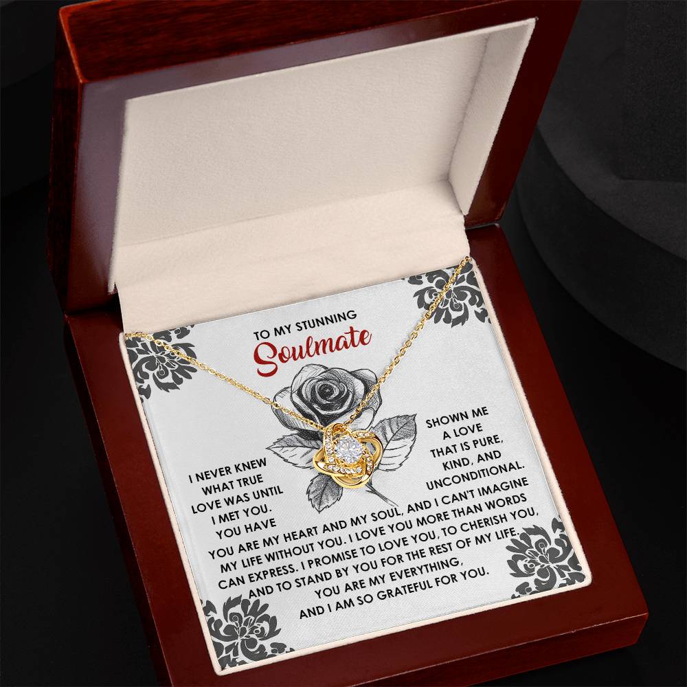 The Soulmate-Cherish You Love Knot Necklace, featuring gleaming cubic zirconia crystals, sits elegantly in an open box next to a card with decorative borders and a rose graphic. The card's heartfelt message for your soulmate makes this personalized gift truly unforgettable.