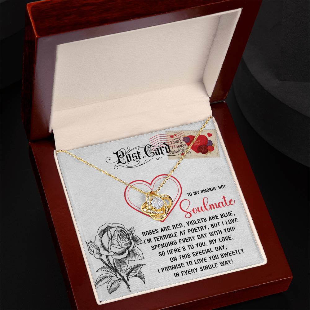 The Soulmate-Special Day - Love Knot Necklace, in yellow gold with an intertwined heart design, rests elegantly inside an open wooden box. It is beautifully displayed on a poem card with a rose illustration and romantic message, adorned with shimmering cubic zirconia crystals.
